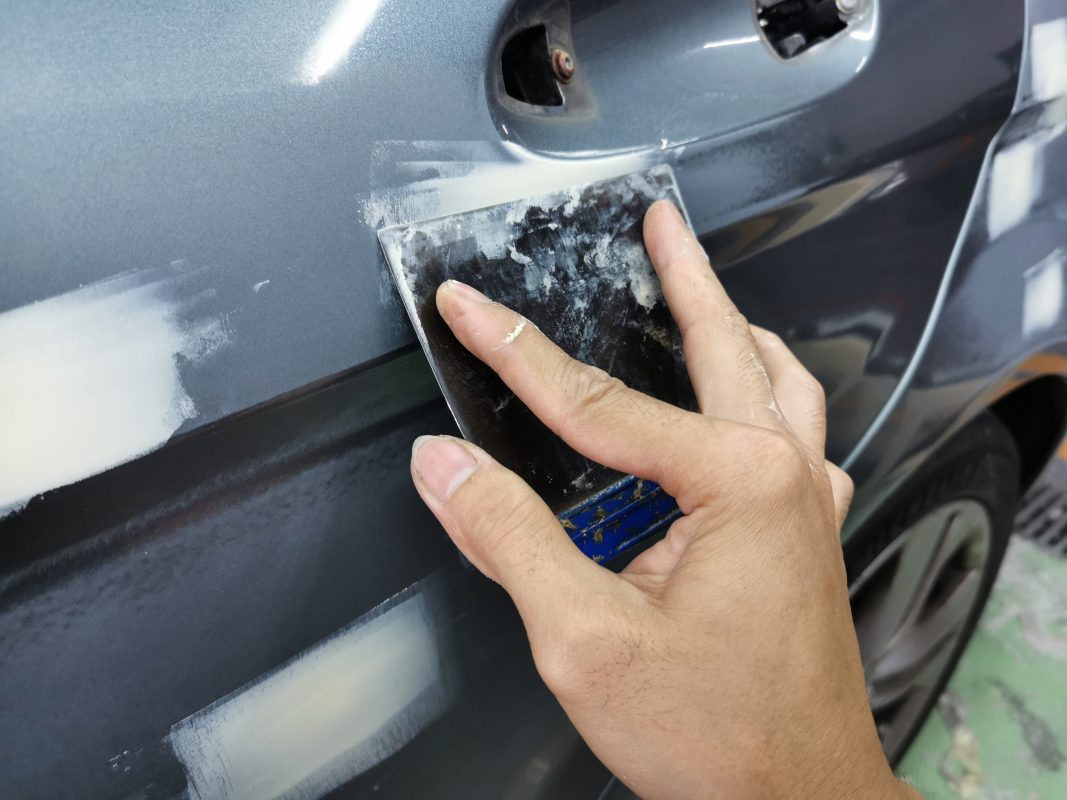 The car's surface inspected and patched where the paintwork was imperfect.