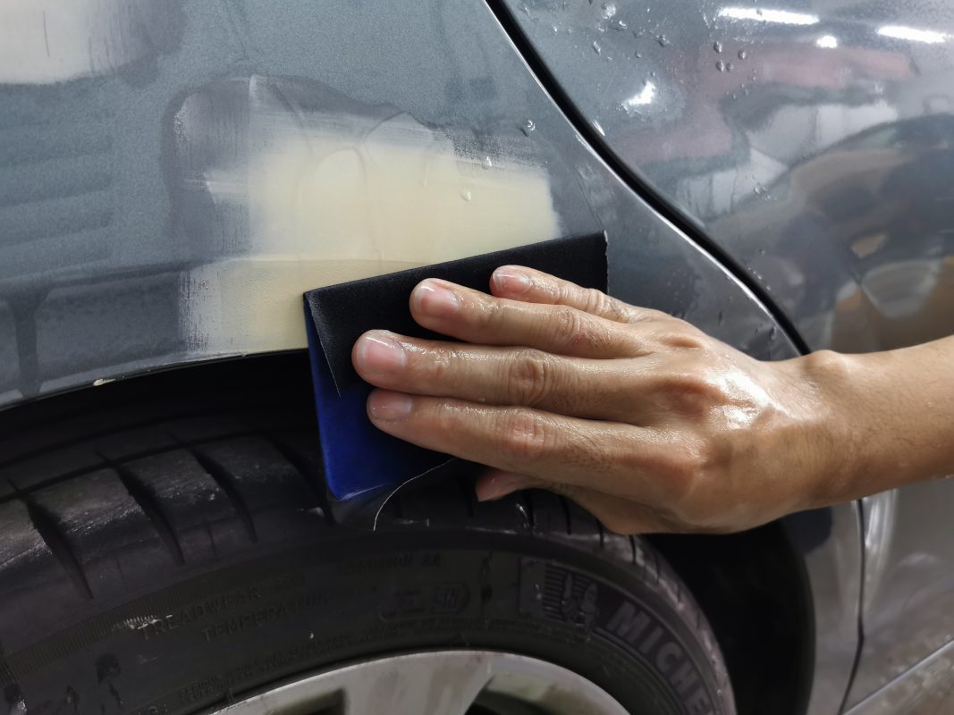 Wet-sanding the C200's panels to smooth the existing paintwork.