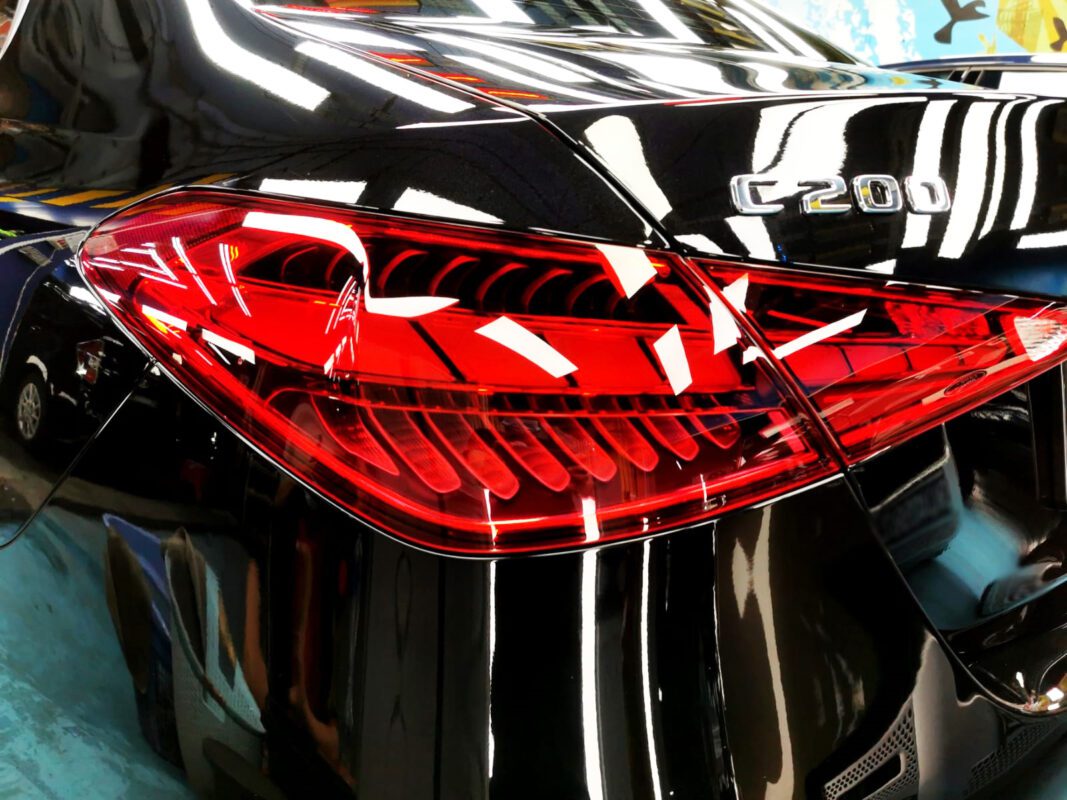 The coated bonnet of the Mercedes-Benz C200 under workshop lighting.