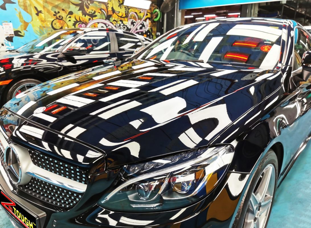 The black Mercedes-Benz C300 from a side angle after the ceramic coating.