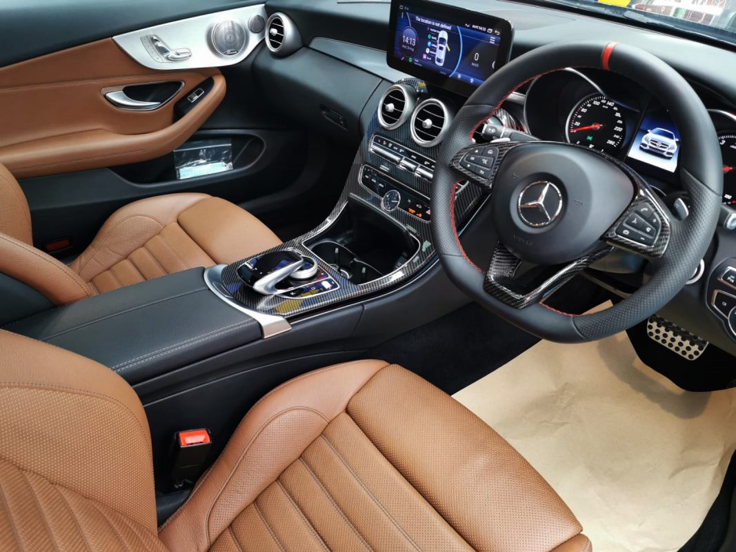 The black Mercedes-Benz C300 parked in the workshop, freshly coated.