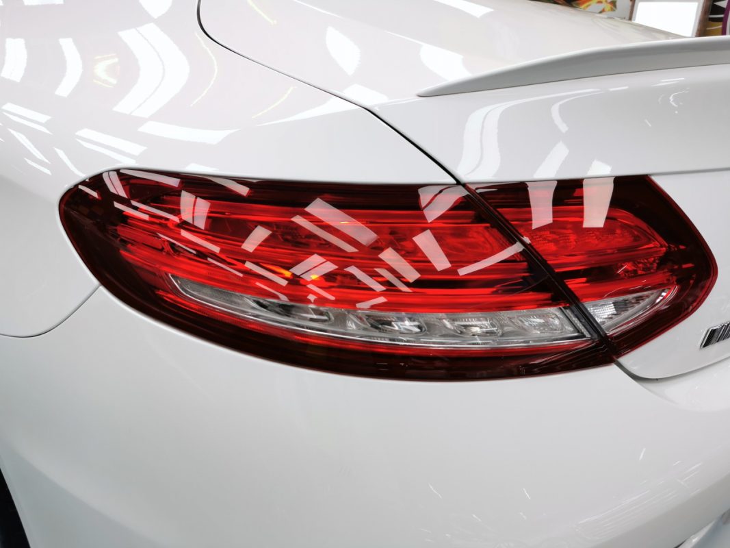 The coated bonnet of the Mercedes-Benz C43 AMG under workshop lighting.
