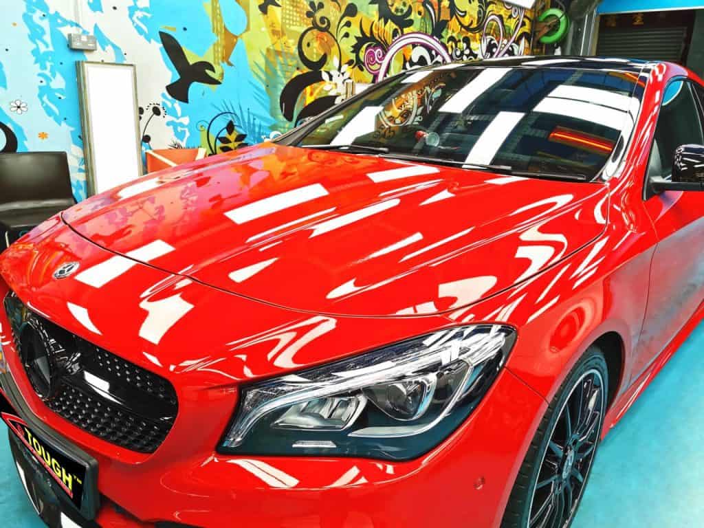 The red Mercedes-Benz CLA 180 from a side angle after the ceramic coating.