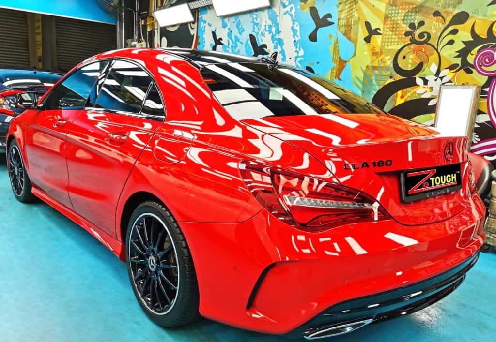 Rear quarter of the red Mercedes-Benz CLA 180, glossy and protected.