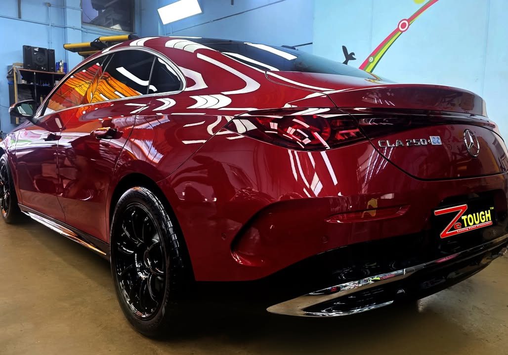 Rear three-quarter view of the red Mercedes-Benz CLA with black alloy wheel.