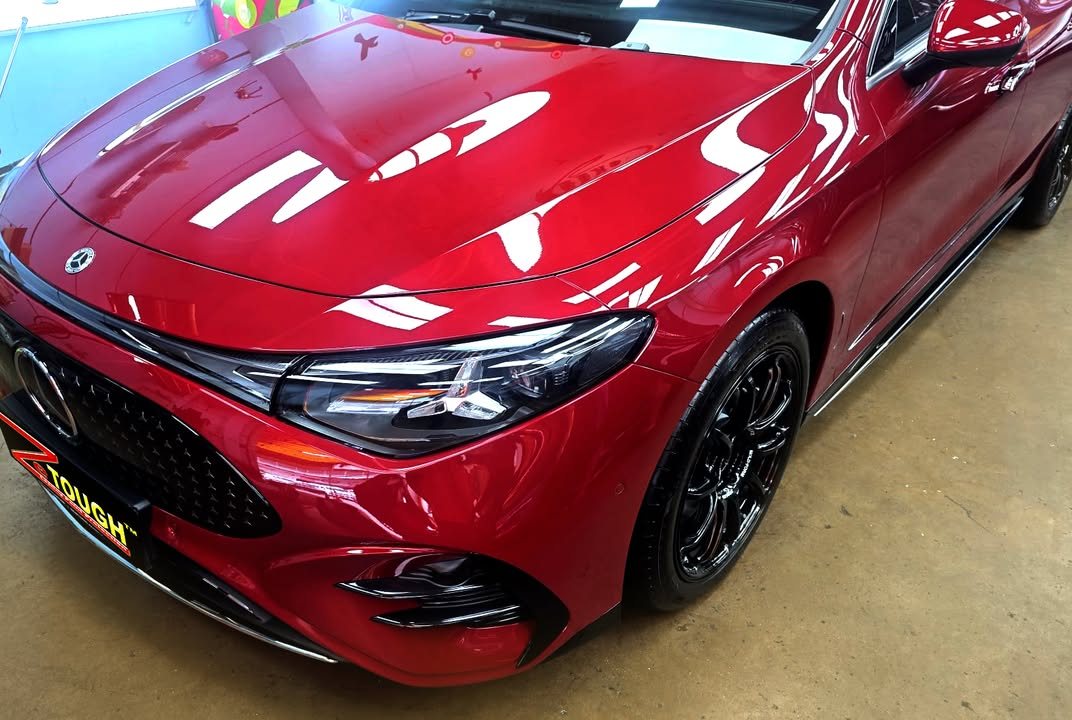 Red bonnet and front wing of the CLA reflecting the workshop lights.