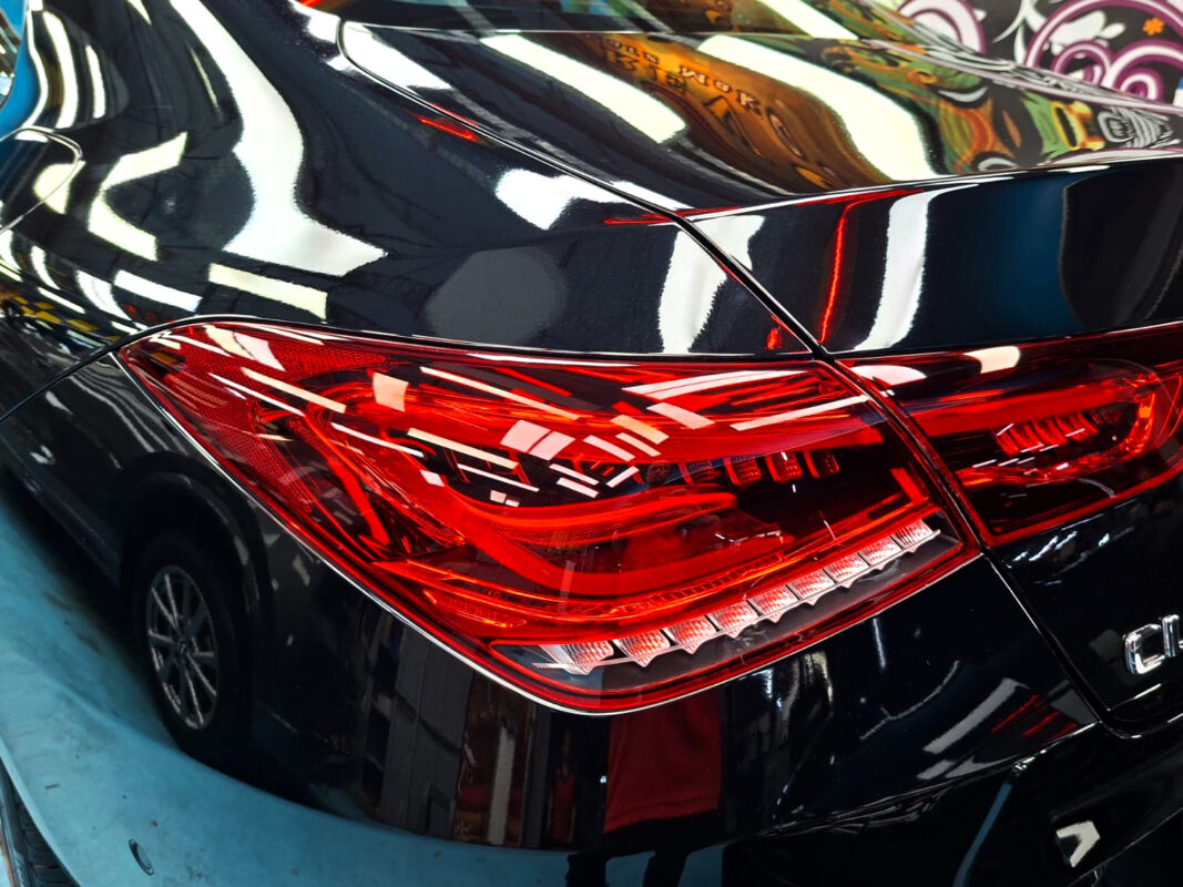 The coated bonnet of the Mercedes-Benz CLA180 under workshop lighting.