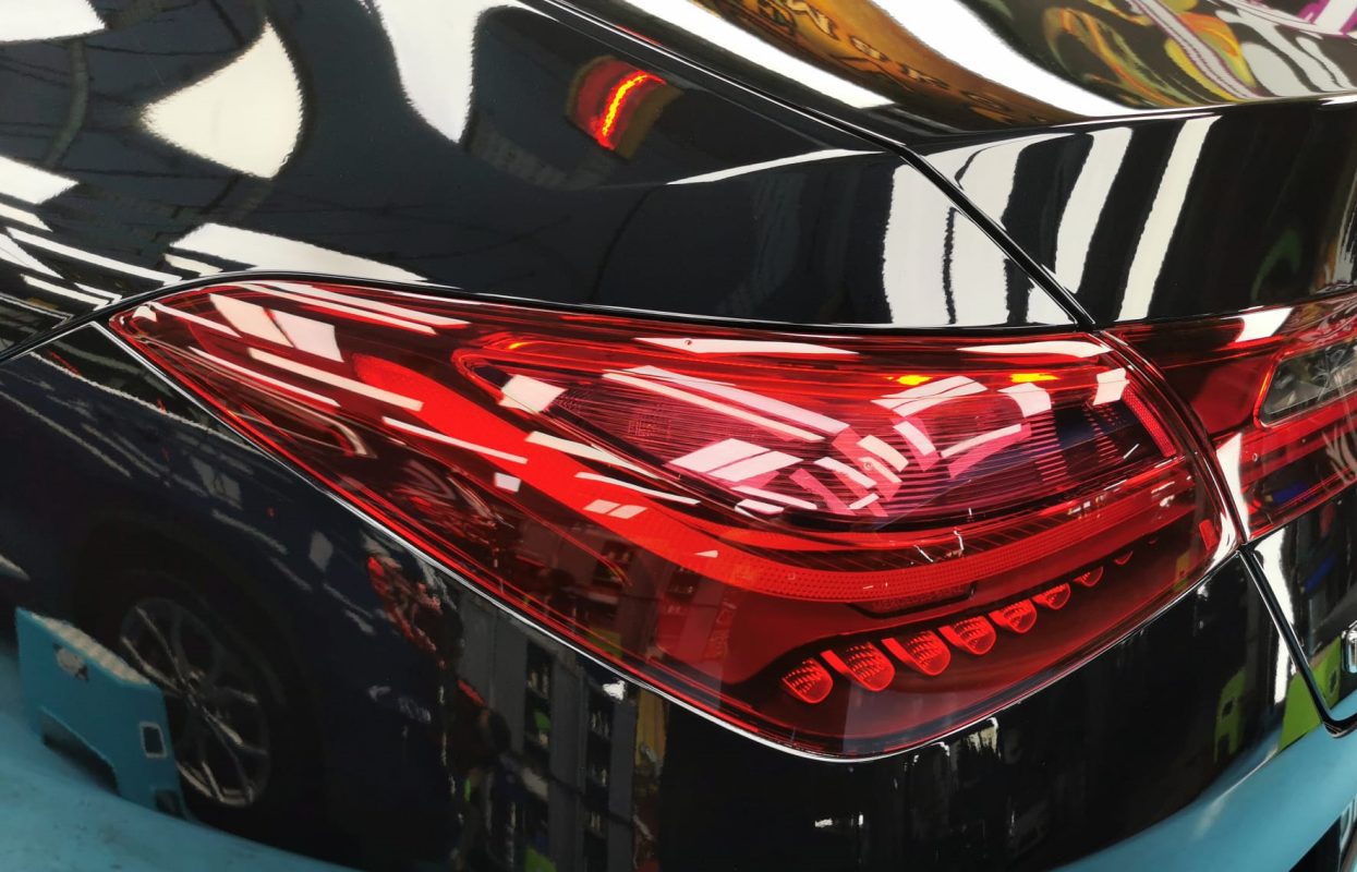 The coated bonnet of the Mercedes-Benz CLA180 under workshop lighting.