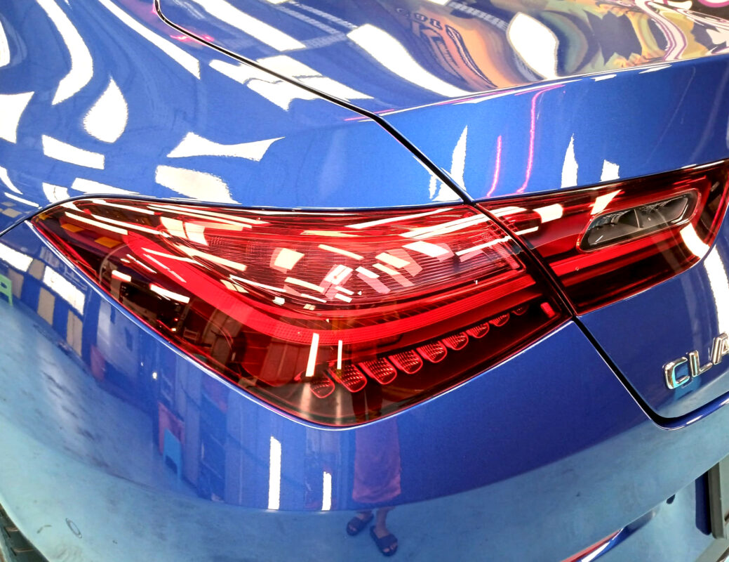 The coated bonnet of the Mercedes-Benz CLA180 under workshop lighting.