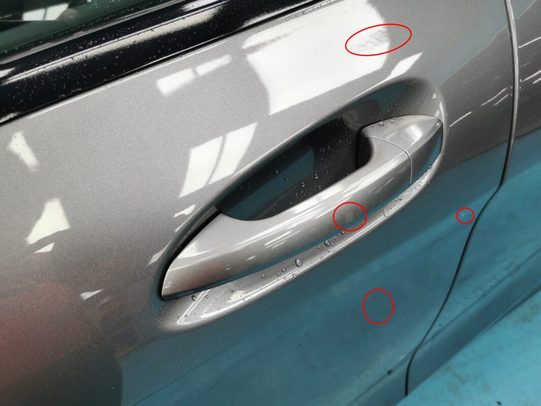 A close-up of the CLA180's paint surface, showing stone chips and surface damage.