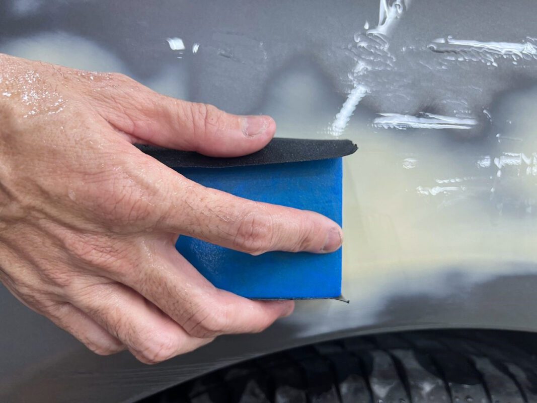 Wet-sanding the CLA180's bodywork to bring the surface smooth before priming.