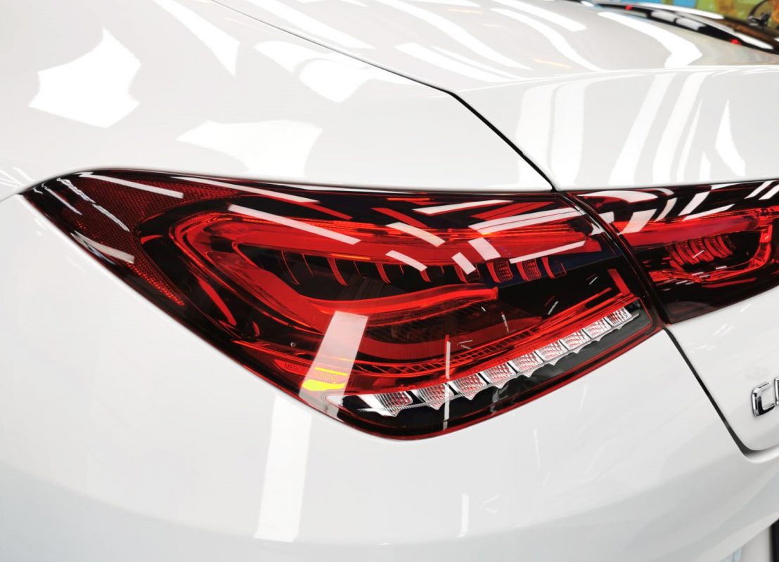 The coated bonnet of the Mercedes-Benz CLA180 under workshop lighting.