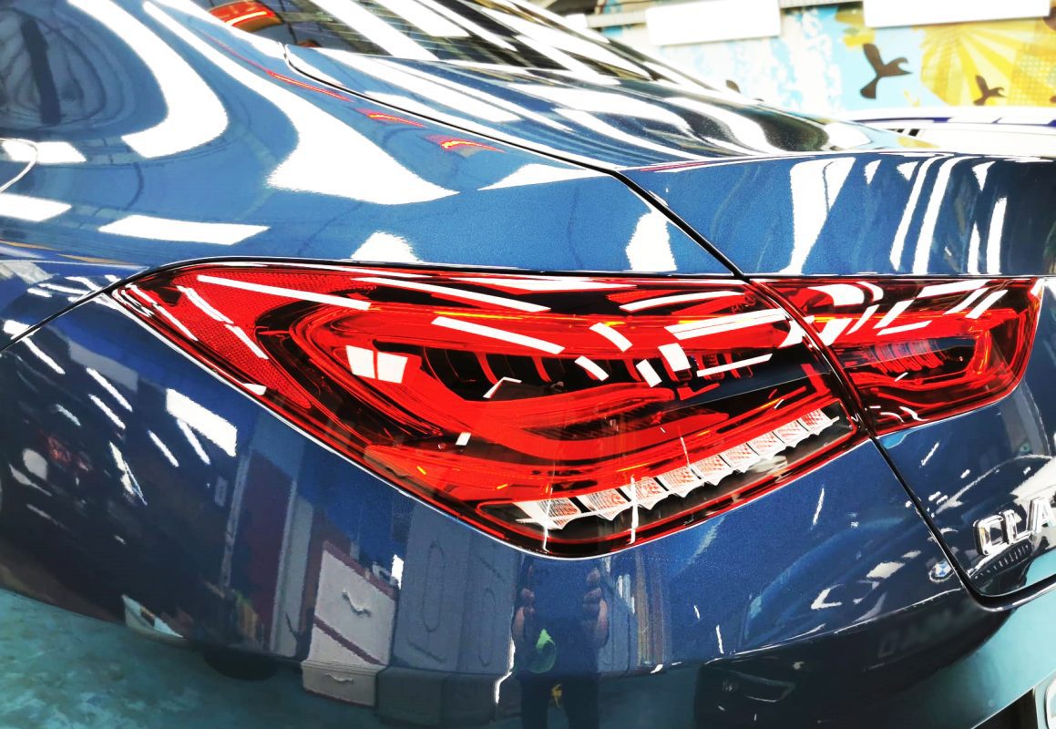 The coated bonnet of the Mercedes-Benz CLA180 under workshop lighting.