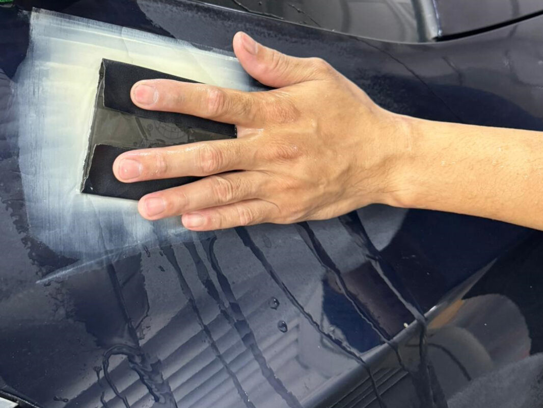 Wet-sanding the CLA200 body panel to a smooth, level surface.