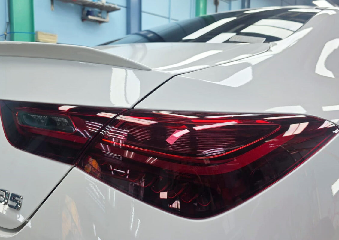 The coated bonnet of the Mercedes-Benz CLA35 under workshop lighting.