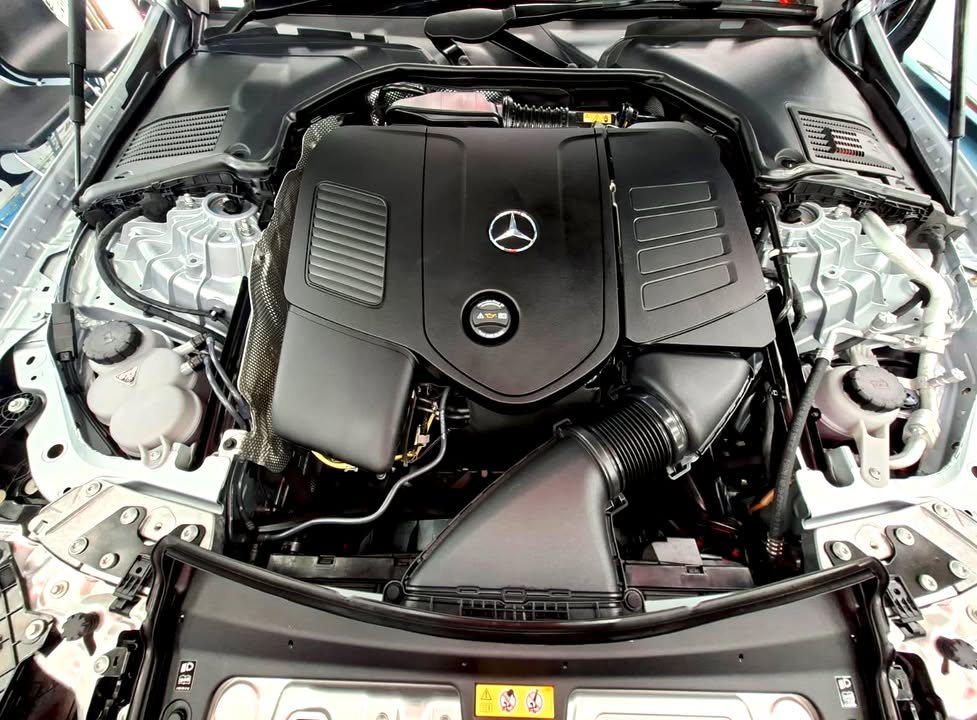 Engine bay with the engine cover and Mercedes-Benz star.