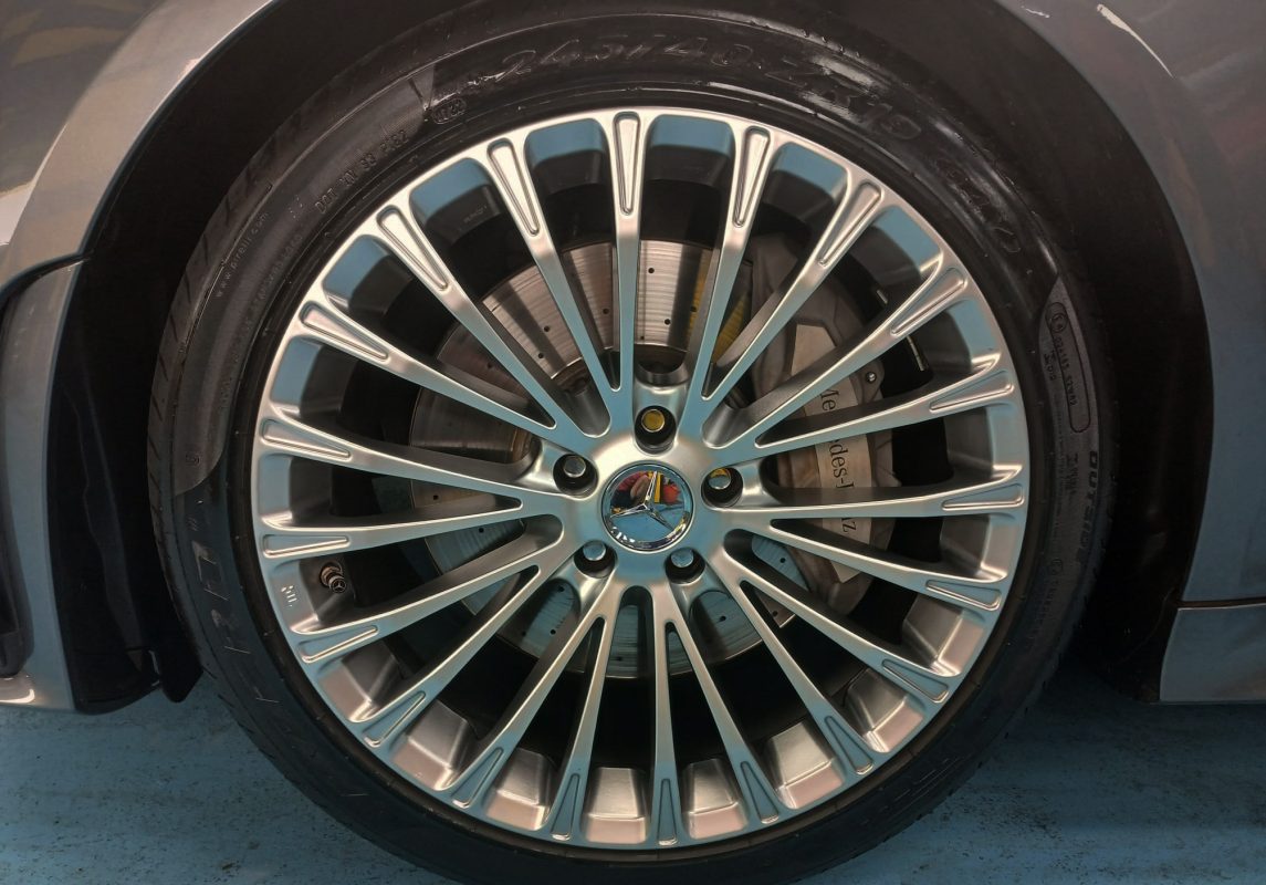 The coated bonnet of the Mercedes-Benz CLS350 under workshop lighting.