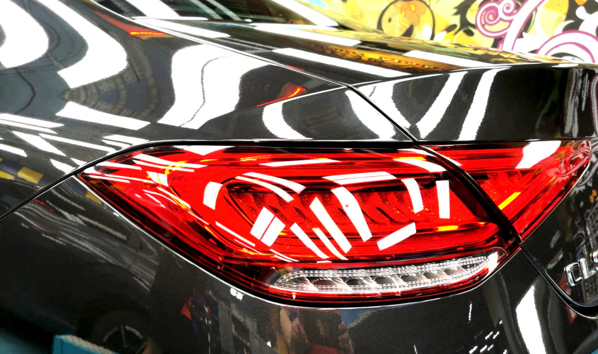 The coated bonnet of the Mercedes-Benz CLS450 under workshop lighting.