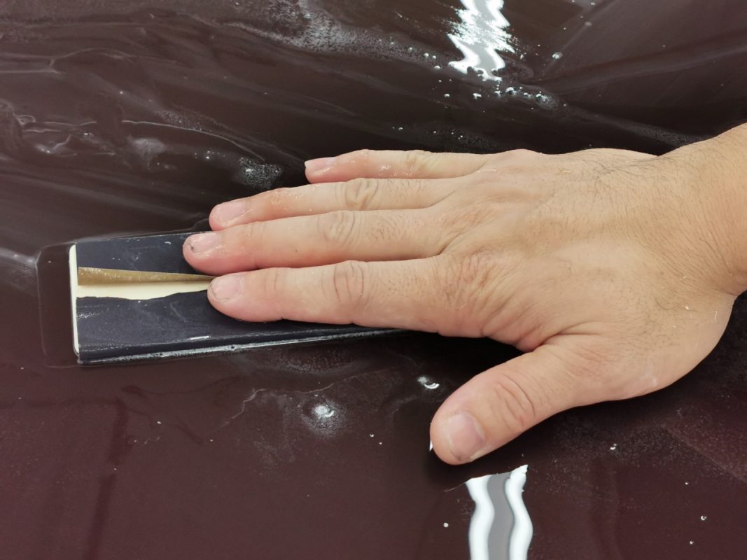 Wet-sanding the E200's panels to smooth the existing paintwork.