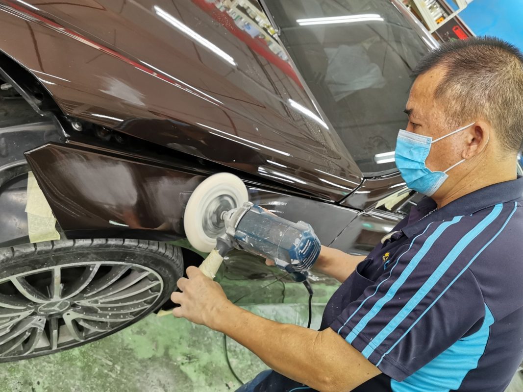 The E200 being touched up after spraying for an even surface.