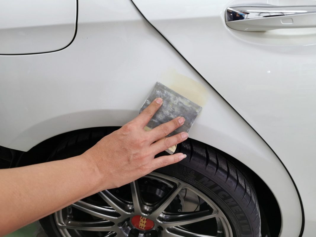 Chipped areas on the E200 being patched before spraying.