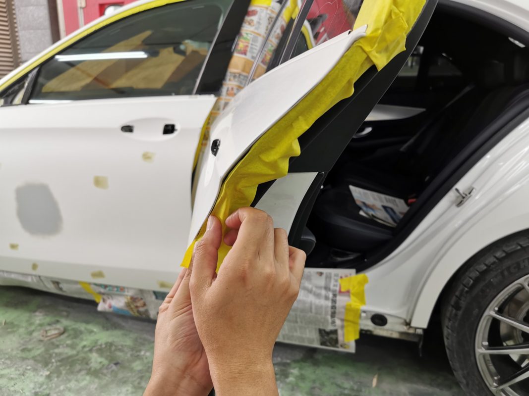Non-painted surfaces being masked off on the E200 before spraying.