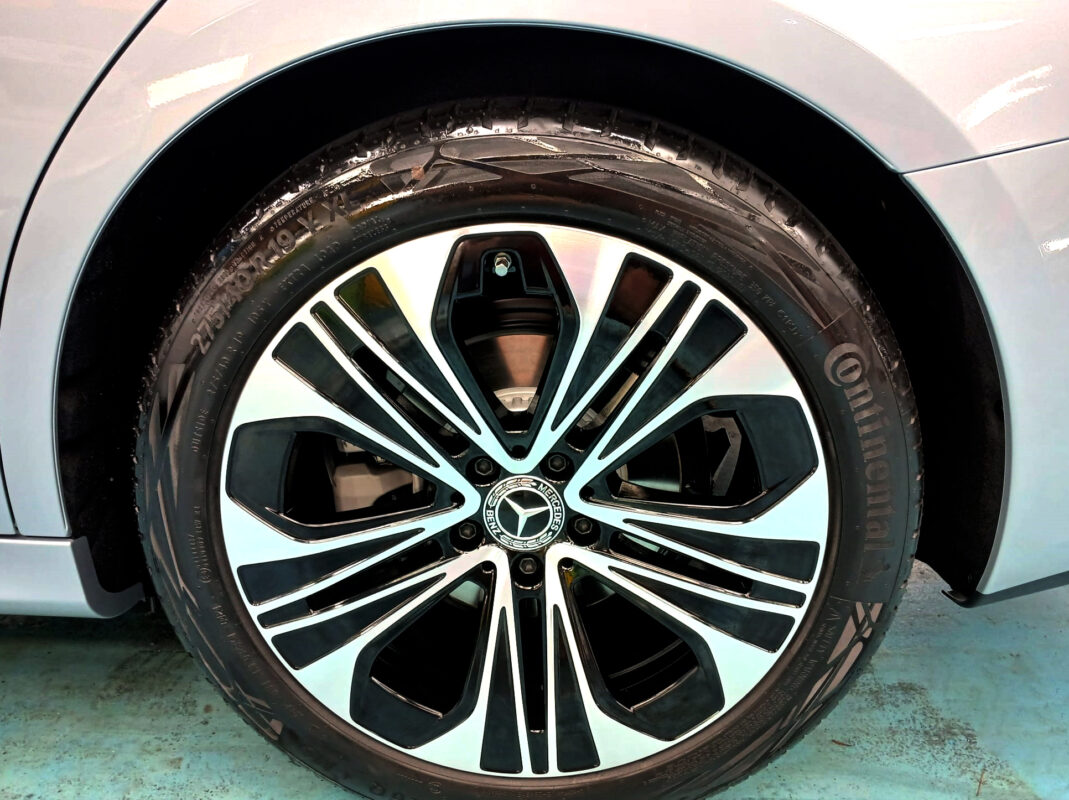 The coated bonnet of the Mercedes-Benz E200 under workshop lighting.