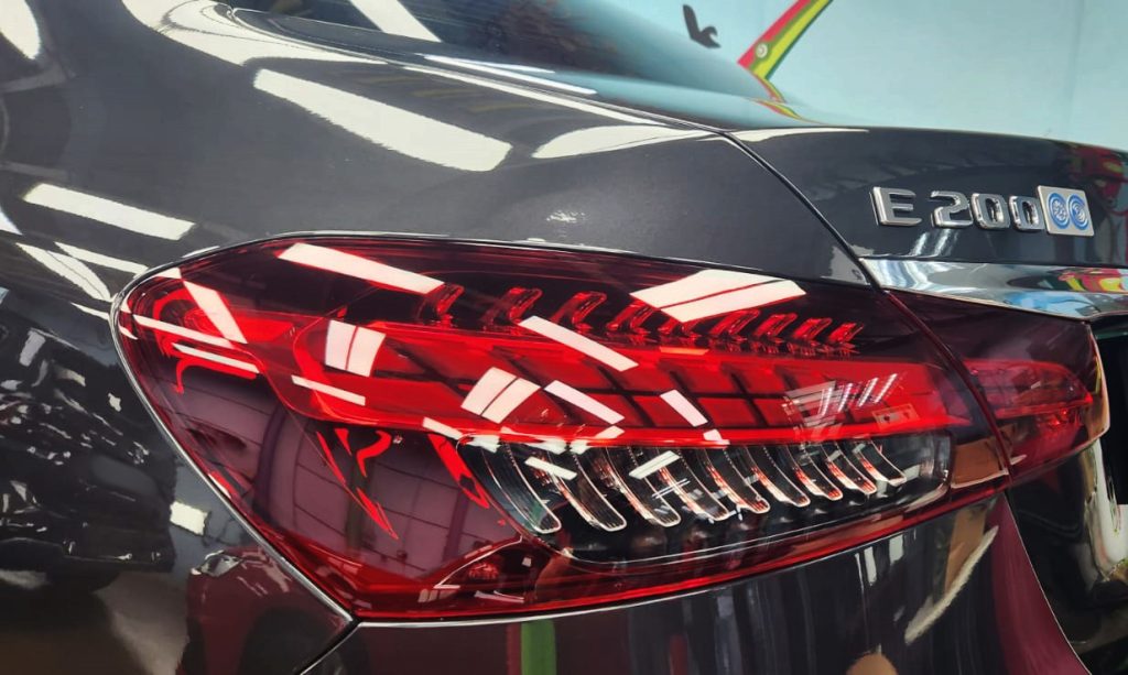 The coated bonnet of the E200 under workshop lighting.