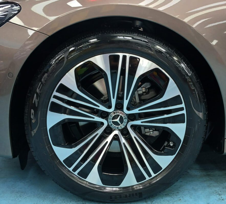 The coated bonnet of the Mercedes-Benz E200 under workshop lighting.