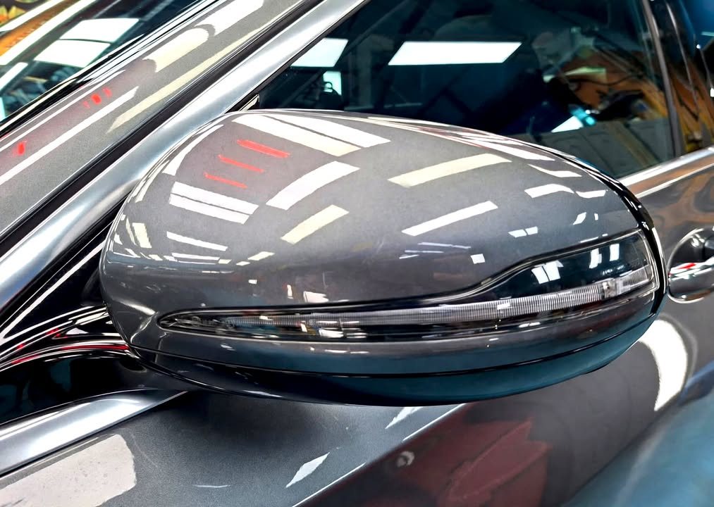 Grey door mirror cap on the Mercedes-Benz E200 with sharp reflections.