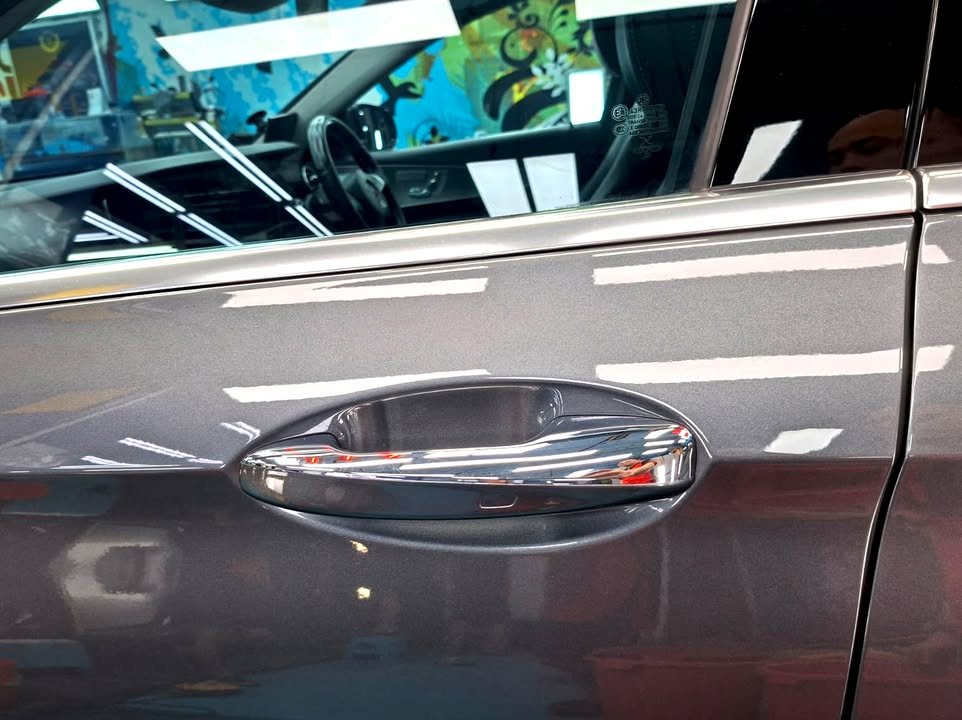 Chrome door handle set into the grey door panel of the E200.