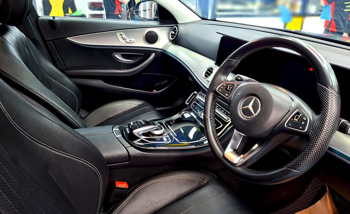 Black leather front seats, steering wheel and centre console inside the E200.