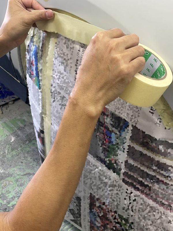 Non-painted surfaces being masked off on the E220d before spraying.