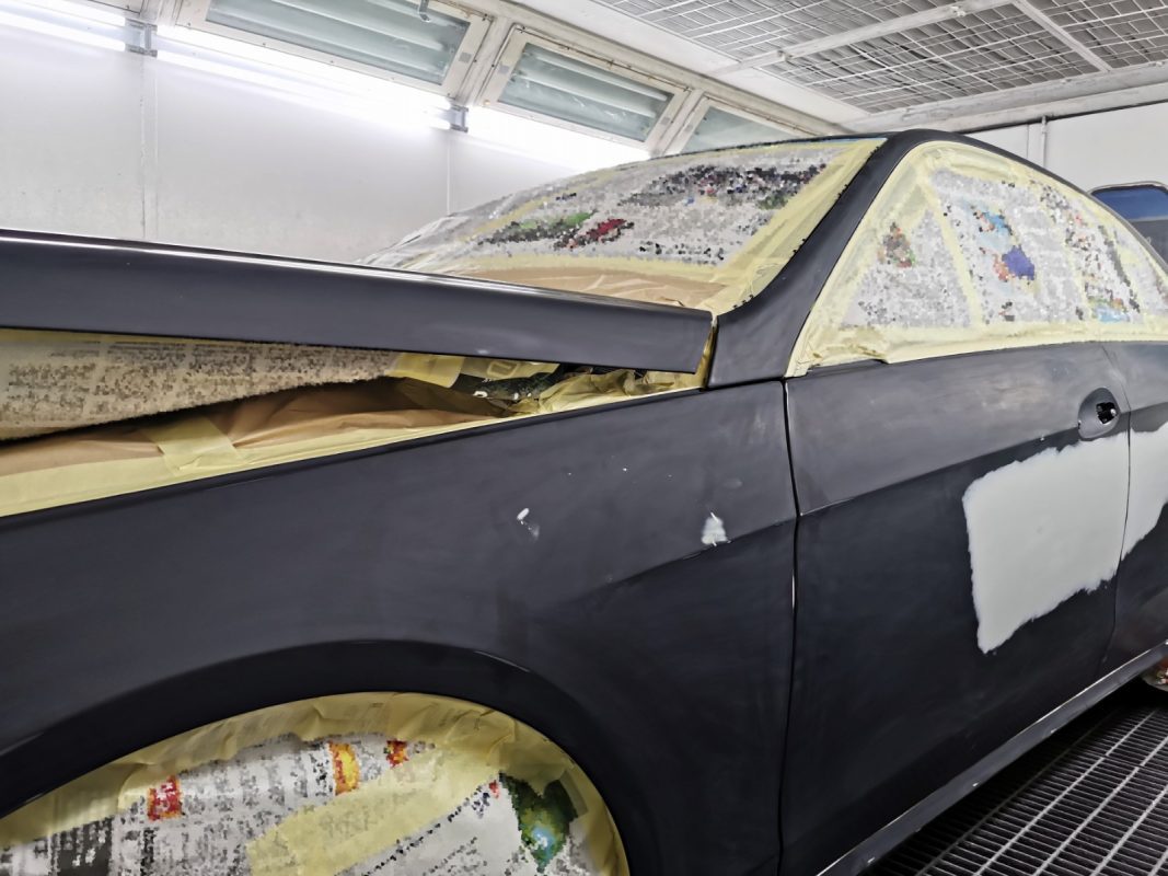 Non-painted surfaces being masked off on the E250 before spraying.