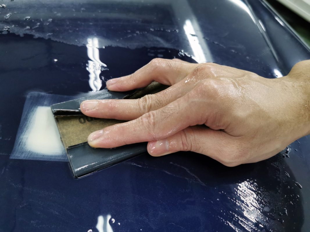 Wet-sanding the E250's panels to smooth the surface.