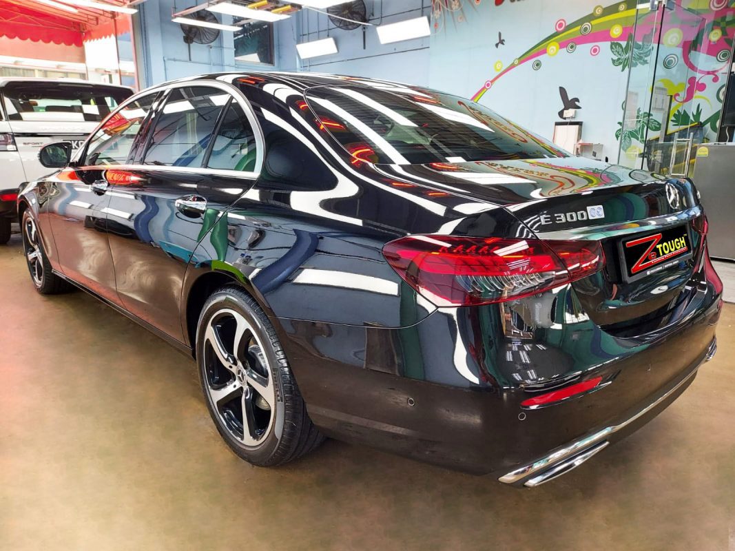Close-up of a coated body panel reflecting the workshop.