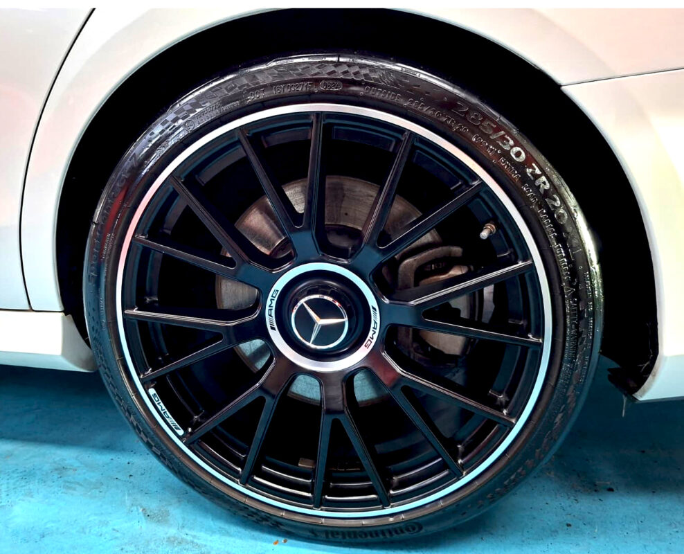 The coated bonnet of the Mercedes-Benz E53 under workshop lighting.