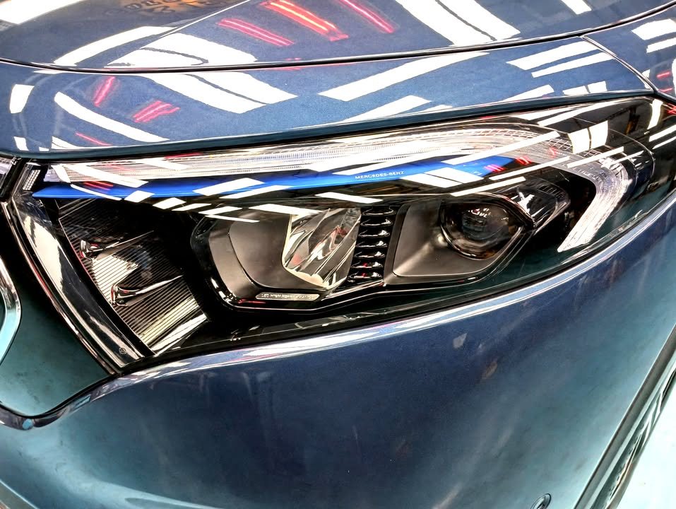 Close view of the EQB headlight and blue front wing.