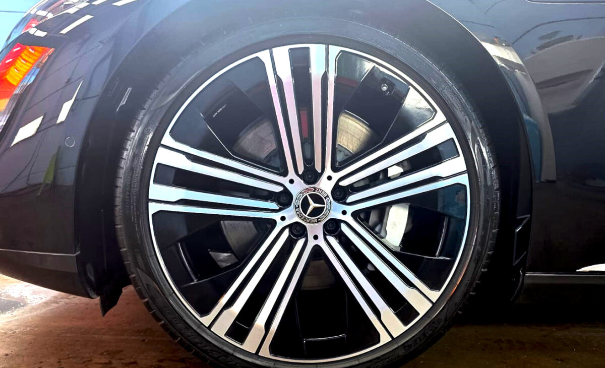 The coated bodywork of the Mercedes-Benz EQS450 under workshop lighting.