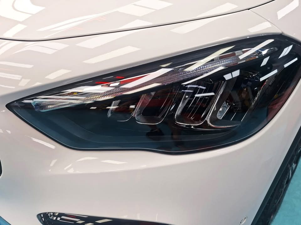 Close-up of the GLA 180's headlamp set into the white front wing.