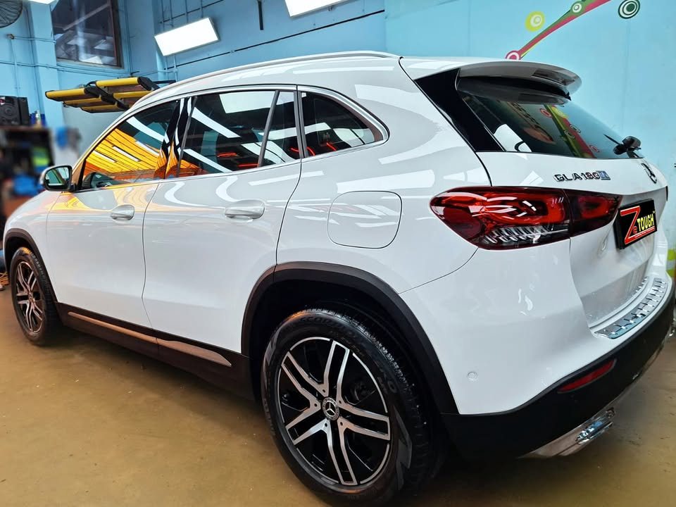 Rear three-quarter view of the white GLA 180 showing the tail lamps and wheels.