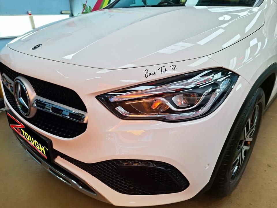 Front grille, headlamp and bonnet of the white GLA 180 up close.