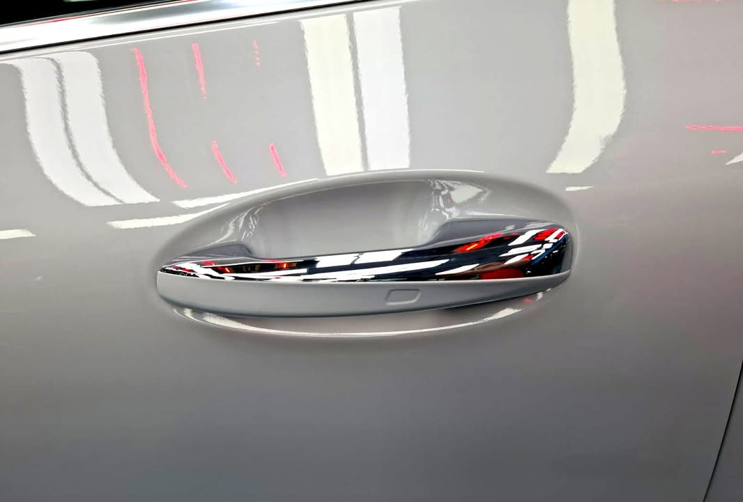 Chrome door handle on the white GLA 200 with light reflected in the panel.