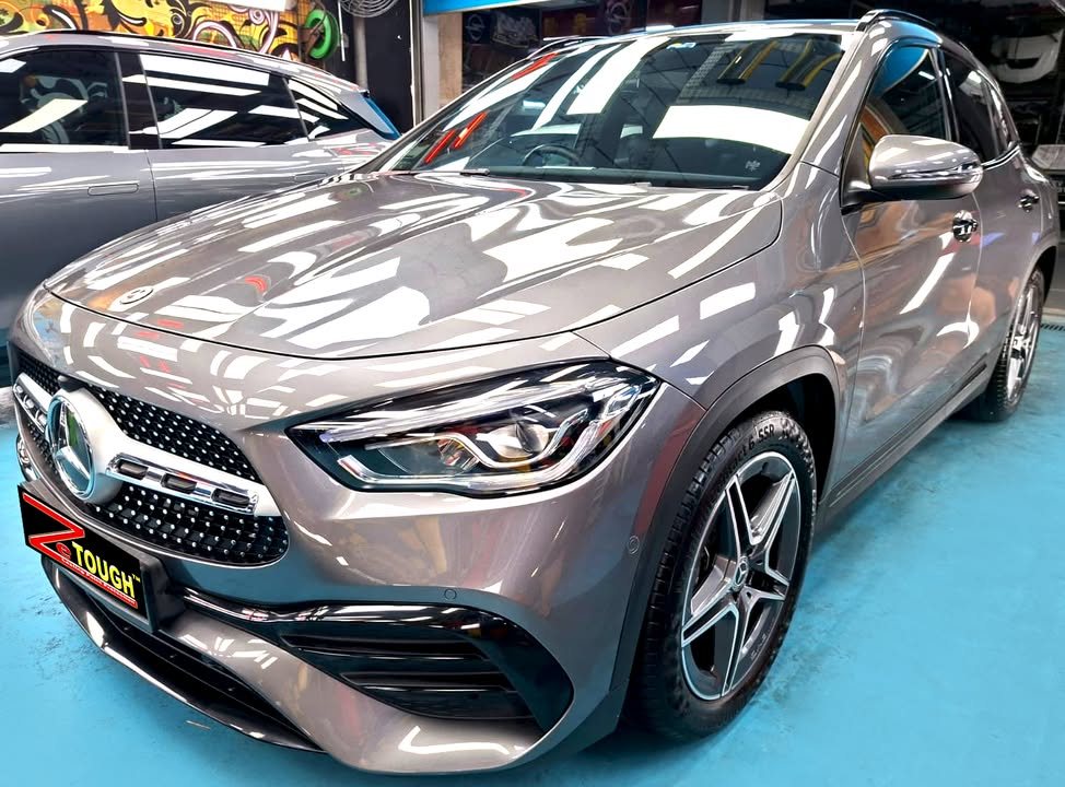 Grey Mercedes-Benz GLA 200, front three-quarter view in the workshop with a ZeTough plate on the bumper.