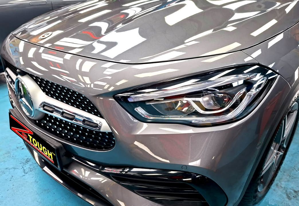 Front of the grey GLA 200 showing the grille, headlamp and bonnet reflections.