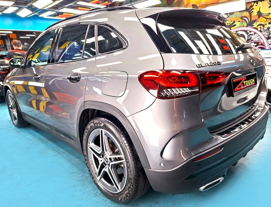 Rear three-quarter view of the grey GLA 200 in the workshop.