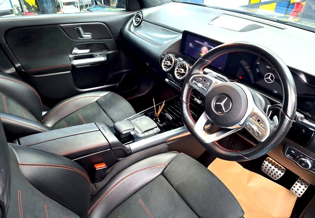 GLA 200 cabin with black seats, steering wheel and twin dashboard screens.