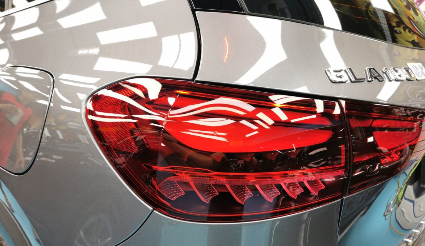 The coated bonnet of the Mercedes-Benz GLA180 under workshop lighting.