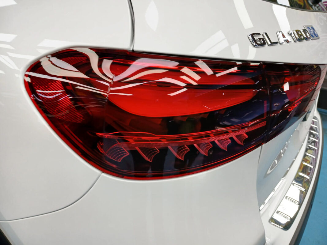 The coated bonnet of the Mercedes-Benz GLA180 under workshop lighting.