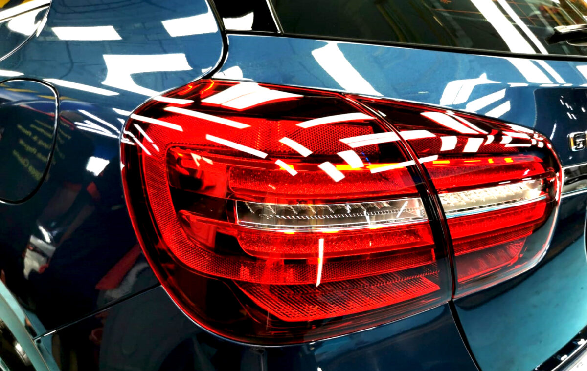 The coated bonnet of the Mercedes-Benz GLA180 under workshop lighting.